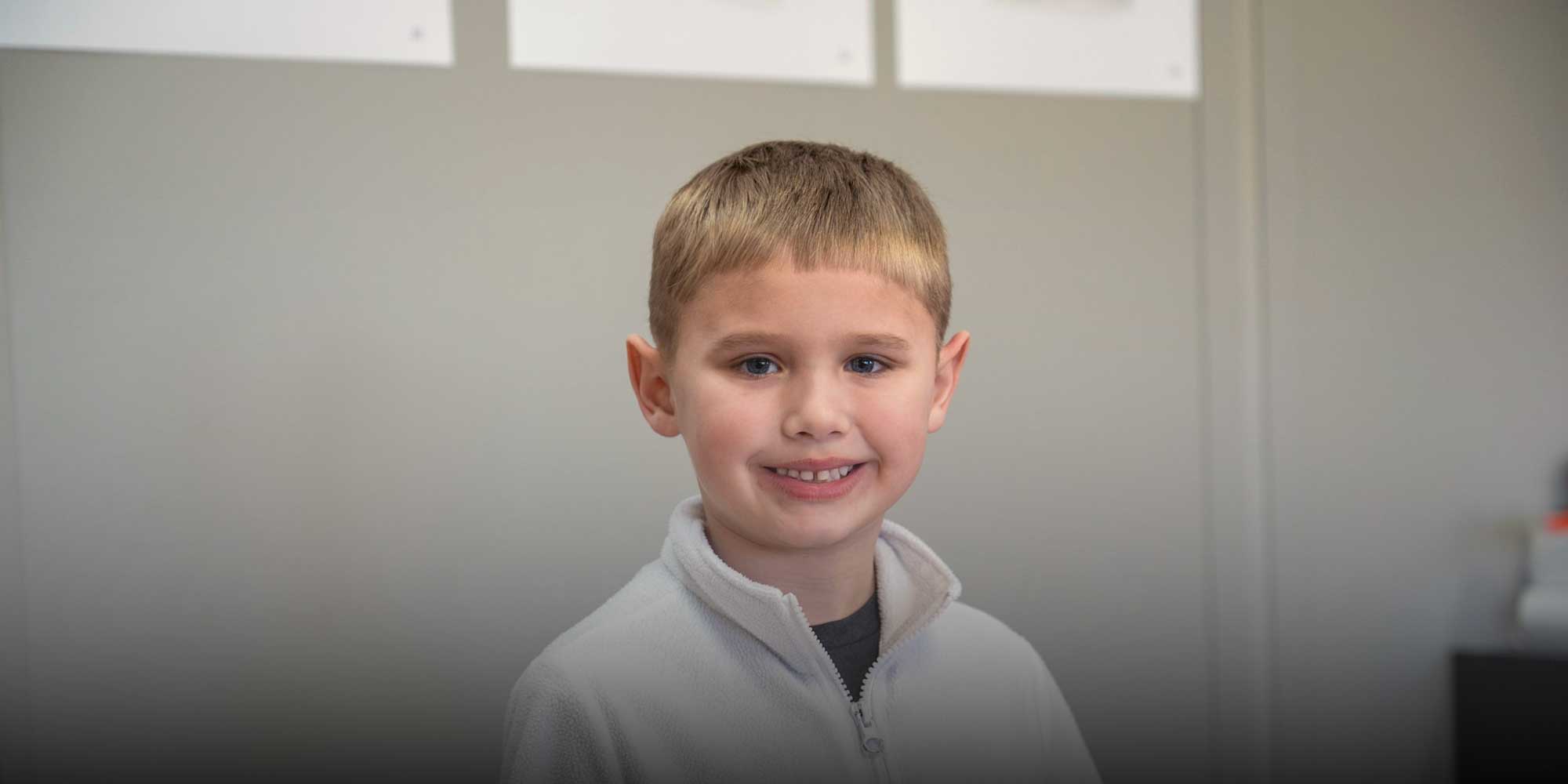 Smiling young student in a light fleece jacket.