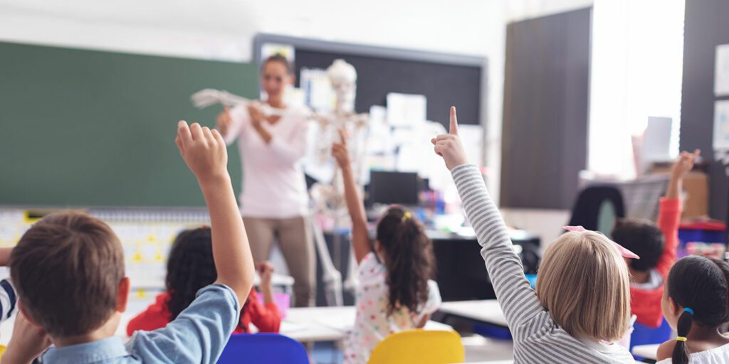 Teacher at front of elementary class teaching a science lesson.