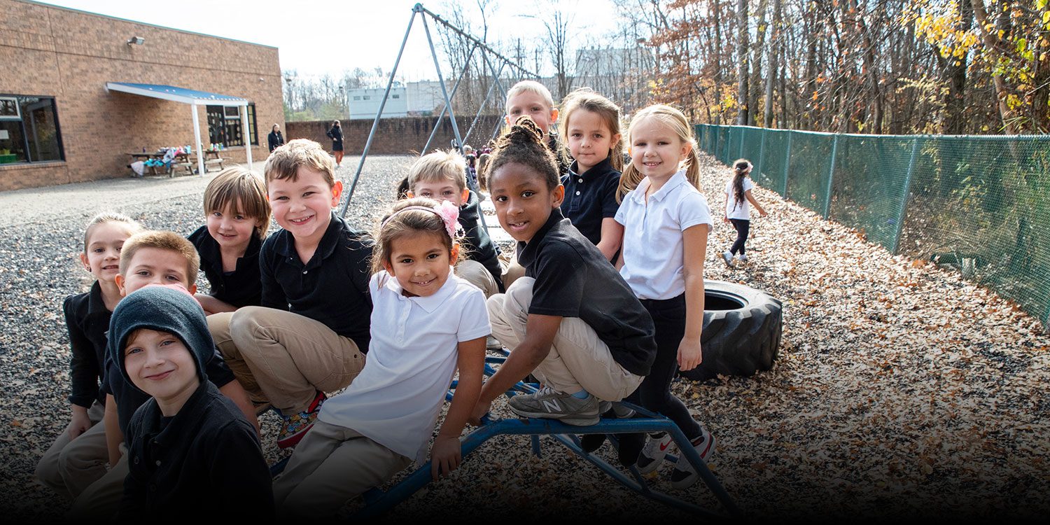A group of happy students sitting on the playing field